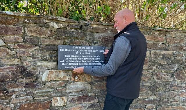 Clive Benney placing the plaque at Rosemundy former mother and baby home
